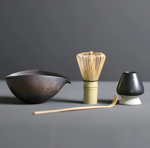 Bol en céramique brune, fouet chasen et porte-fouet noir : le même matériel sert au hojicha en poudre
